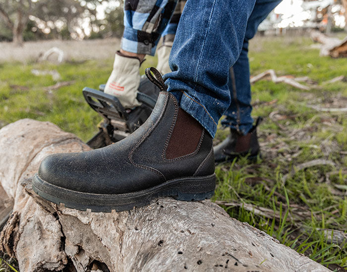 Person stood on a log, wearing a pair of Hard Yakka Banjo work boots